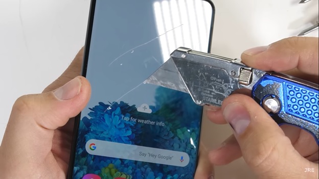 Đầu tiên, Galaxy S20 Ultra được đem ra thử độ bền với dao rọc giấy. Đã có nhiều vết xước trên bề mặt nhưng đó chỉ là miếng dán bảo vệ Samsung trang bị cho máy..