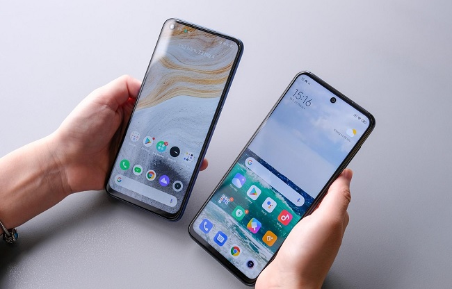 Tay phải là Redmi Note 9S với màn hình “đục lỗ” nằm ở giữa còn tay trái là Realme 6