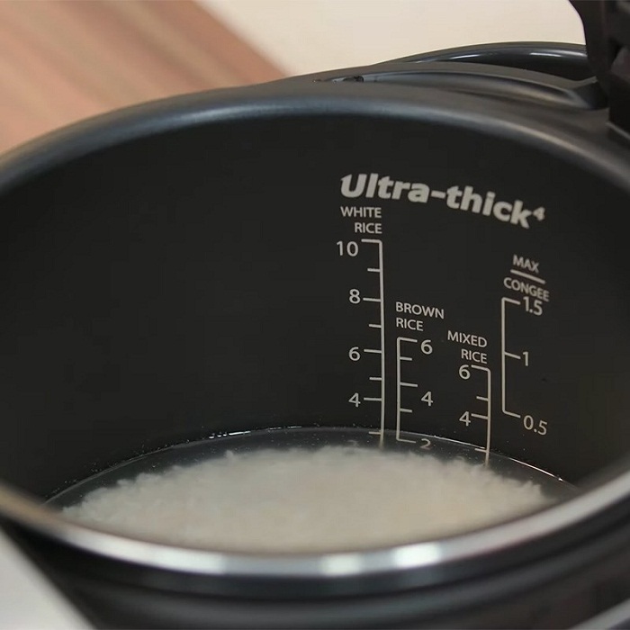 Cho gạo vào nồi và thêm nước