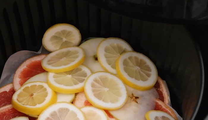 Lót đáy nồi chiên không dầu một lớp giấy nến và xếp hoa quả vào theo từng lớp