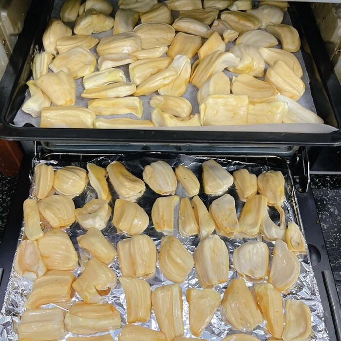 Xếp lần lượt các múi mít đã sơ chế vào khay nướng