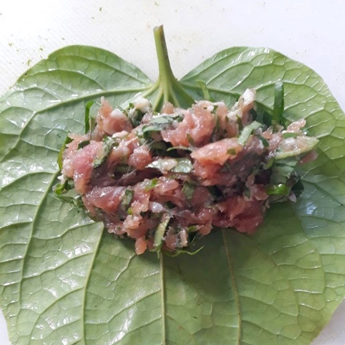 Múc 1 muỗng canh thịt đã ướp gia vị bỏ vào, rồi khéo léo gấp cuộn lại