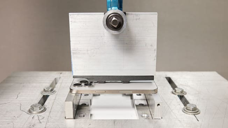 Máy thử nén Instron đang tạo áp lực trên iPhone 15 Pro Max