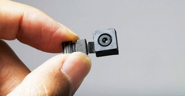 A hand holding a small camera

Description automatically generated