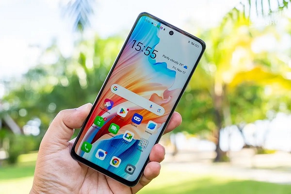 A hand holding a cell phone with a picture of girls

Description automatically generated