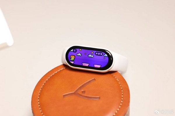 A smart watch on a round brown surface

Description automatically generated