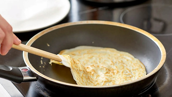 A pancake being fried in a pan

Description automatically generated