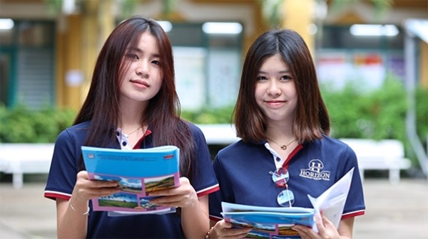 A couple of young women holding books

Description automatically generated