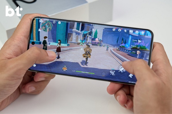 A hand holding a white cell phone
Description automatically generated