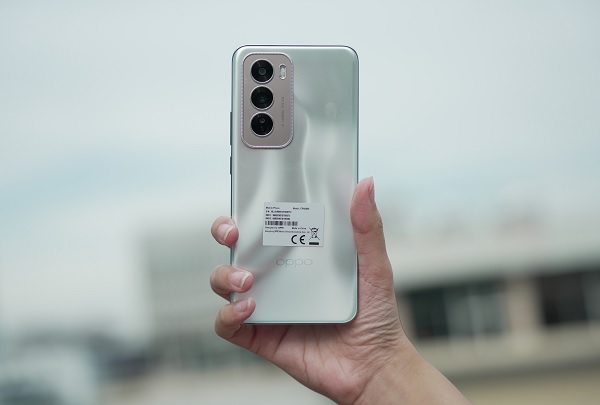 A hand holding a silver cell phone
Description automatically generated