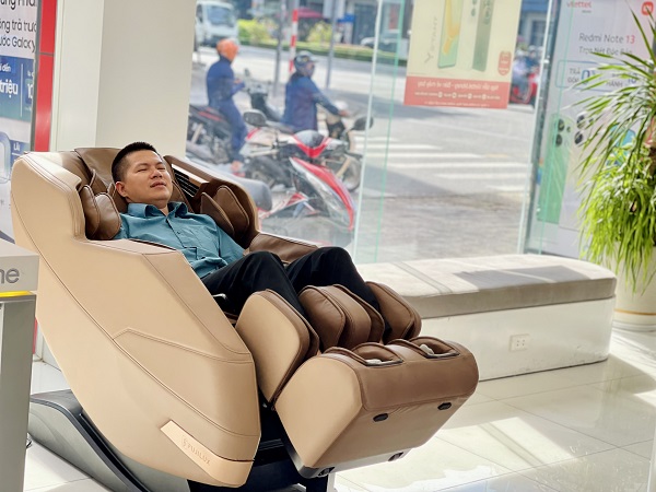 A person in a kimono next to a massage chair

Description automatically generated