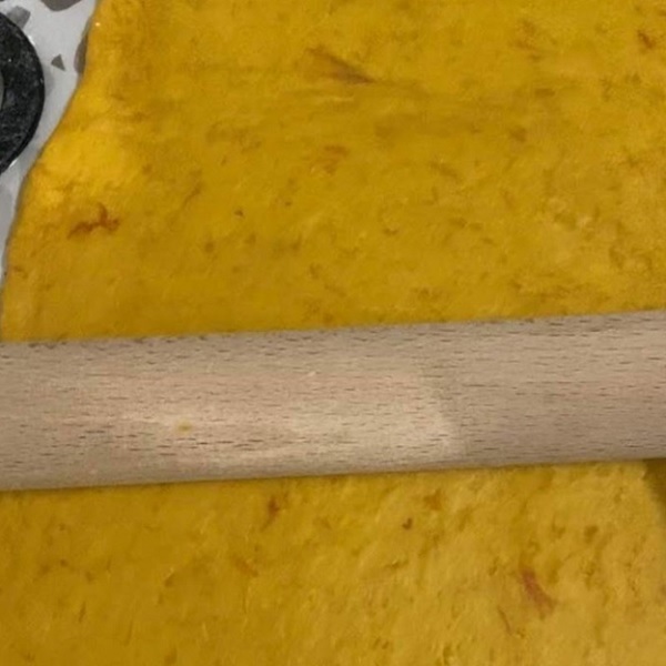 A rolling pin on a yellow surface

Description automatically generated