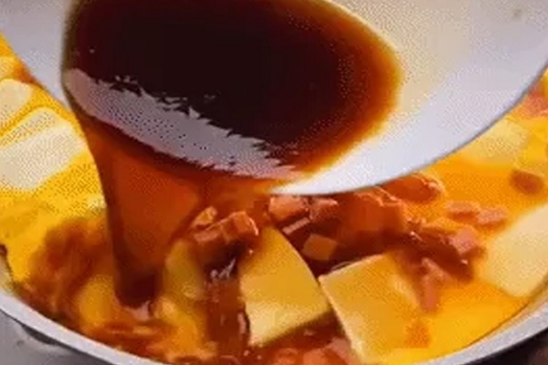A bowl of soup with brown liquid

Description automatically generated
