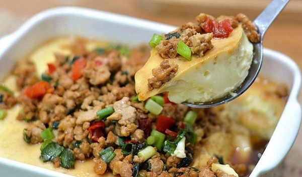 A spoonful of food in a white bowl

Description automatically generated