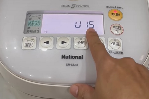 A hand pressing a button on a machine
Description automatically generated