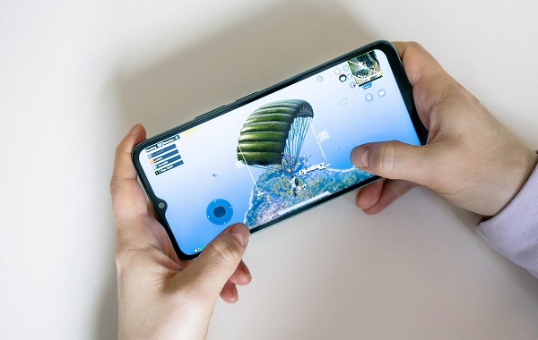 A hand holding a green cell phone
Description automatically generated