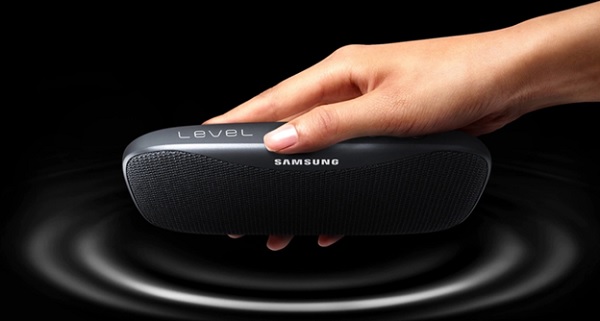 A hand holding a speaker

Description automatically generated