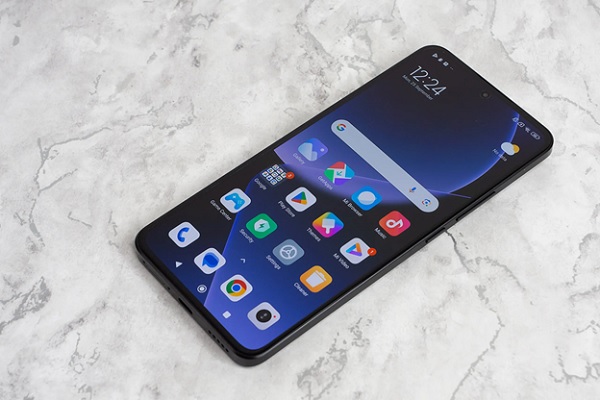 A black cell phone on a marble surface
Description automatically generated