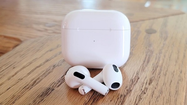 A white earbuds next to a box
Description automatically generated