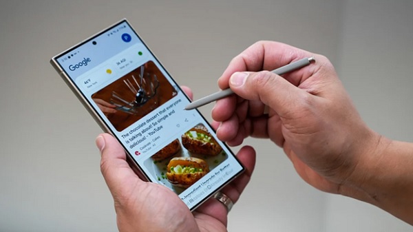 A person holding a stylus on a cellphone
Description automatically generated