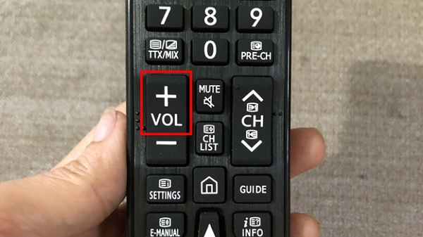 A hand holding a remote control
Description automatically generated