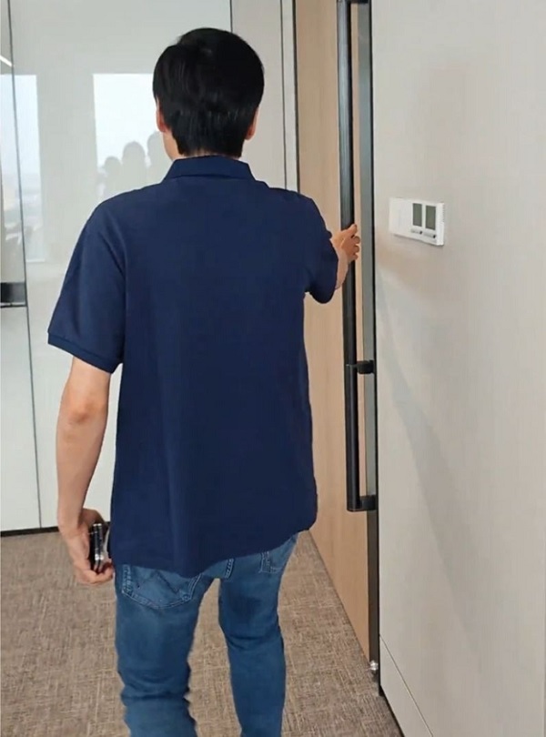 A person holding a door handle
Description automatically generated