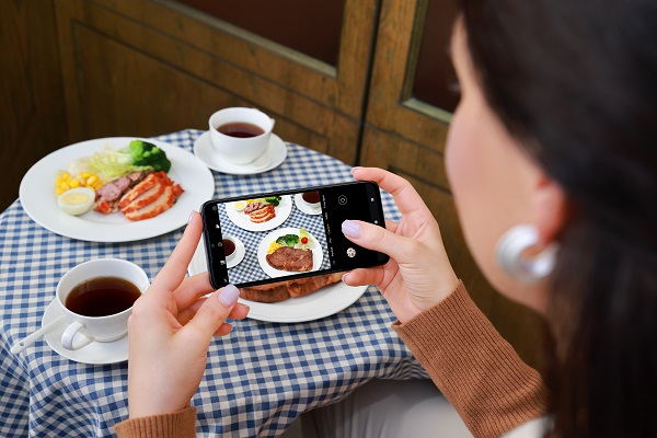 A person taking a picture of food

Description automatically generated