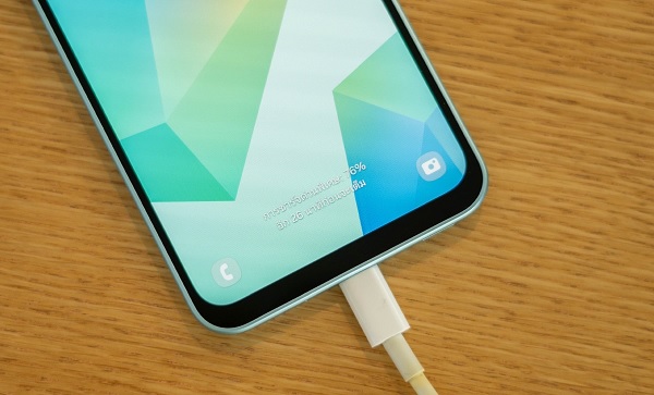 A cell phone charging with a white cord

Description automatically generated