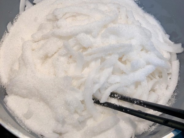 Cho miếng dừa vào tô, thêm đường và muối vào, trộn đều