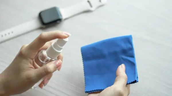 Dùng khăn khô làm sạch bề mặt sạc và mặt lưng Apple Watch