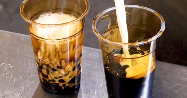 Cho trân châu đường đen vào đáy ly và thêm trà sữa