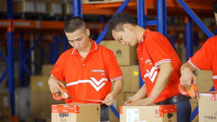 Nhân viên chuyển phát chuẩn bị đóng gói bưu kiện để vận chuyển.