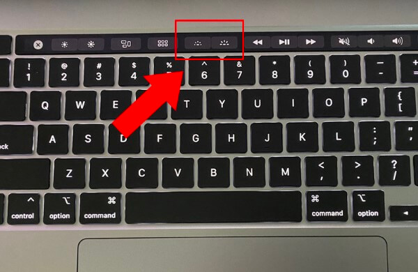 Nhấn nút giảm độ sáng trên Touch Bar nhiều lần hoặc nhấn giữ